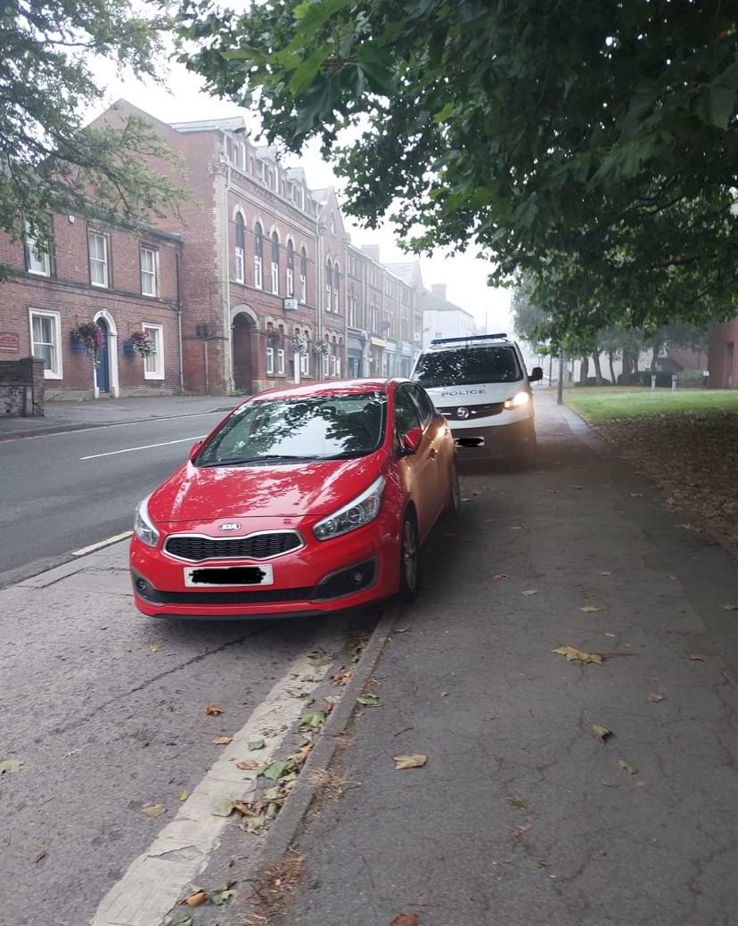 drunk driver An image shared by the police shows a red vehicle parked on a quiet street, with a police van behind it.